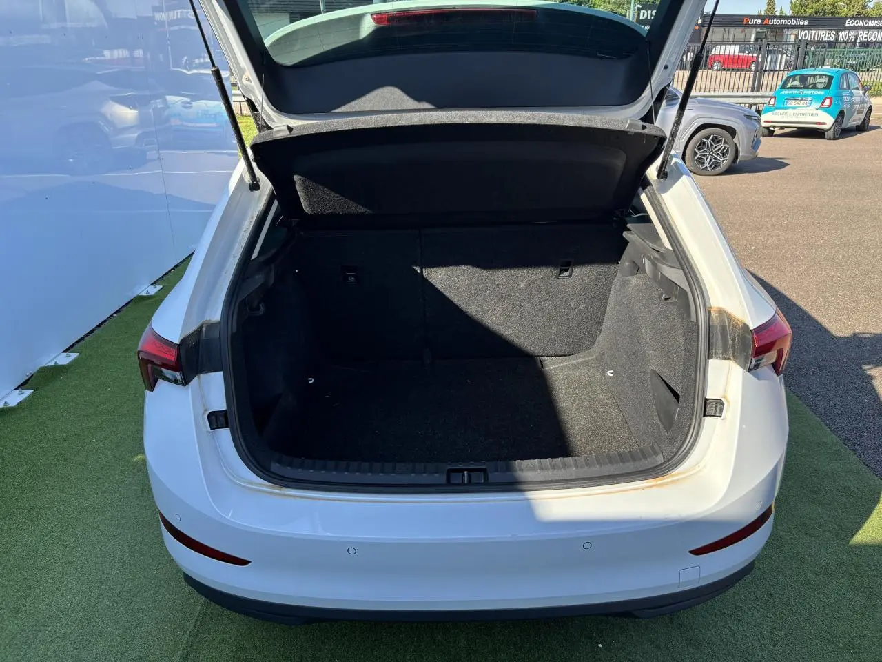 Coffre ouvert vu de l'arrière d'une Skoda Scala blanc glacier 2024, montrant l'espace de chargement vide.