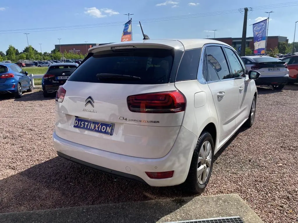 Vue 3/4 arrière droite d'une Citroën C4 Spacetourer blanche avec vitres teintées et feux arrière distinctifs.