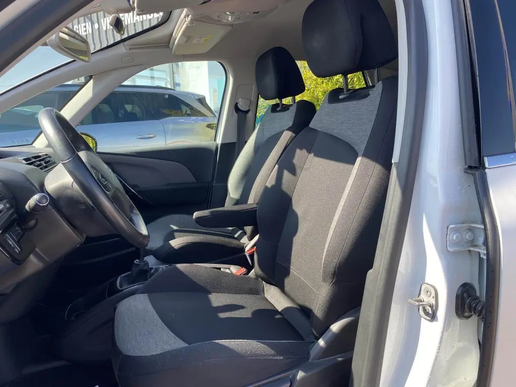 Intérieur avant droit du Citroën C4 Spacetourer blanc 2018, montrant les sièges tissu bicolore et le volant côté conducteur.