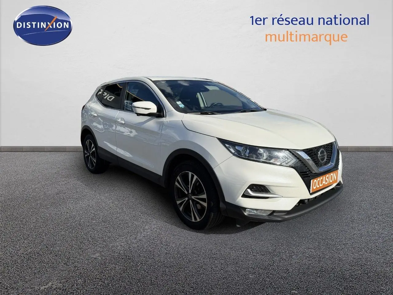 Nissan Qashqai blanc nacré en 3/4 avant droit, avec jantes alliage et plaque orange "OCCASION" visible.