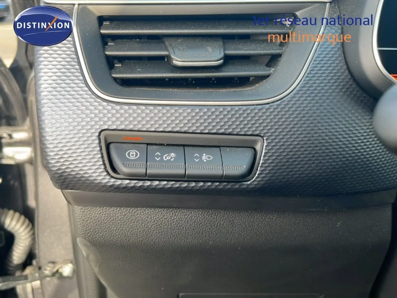 Détail du tableau de bord côté gauche du Renault Arkana 2025 gris Cassiopée, avec commandes d’éclairage et ventilation.