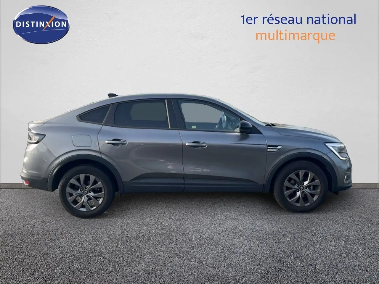 Profil droit du Renault Arkana gris cassiopée métallisé, version 1.3 mild hybrid 140ch avec jantes alliage et feux LED.