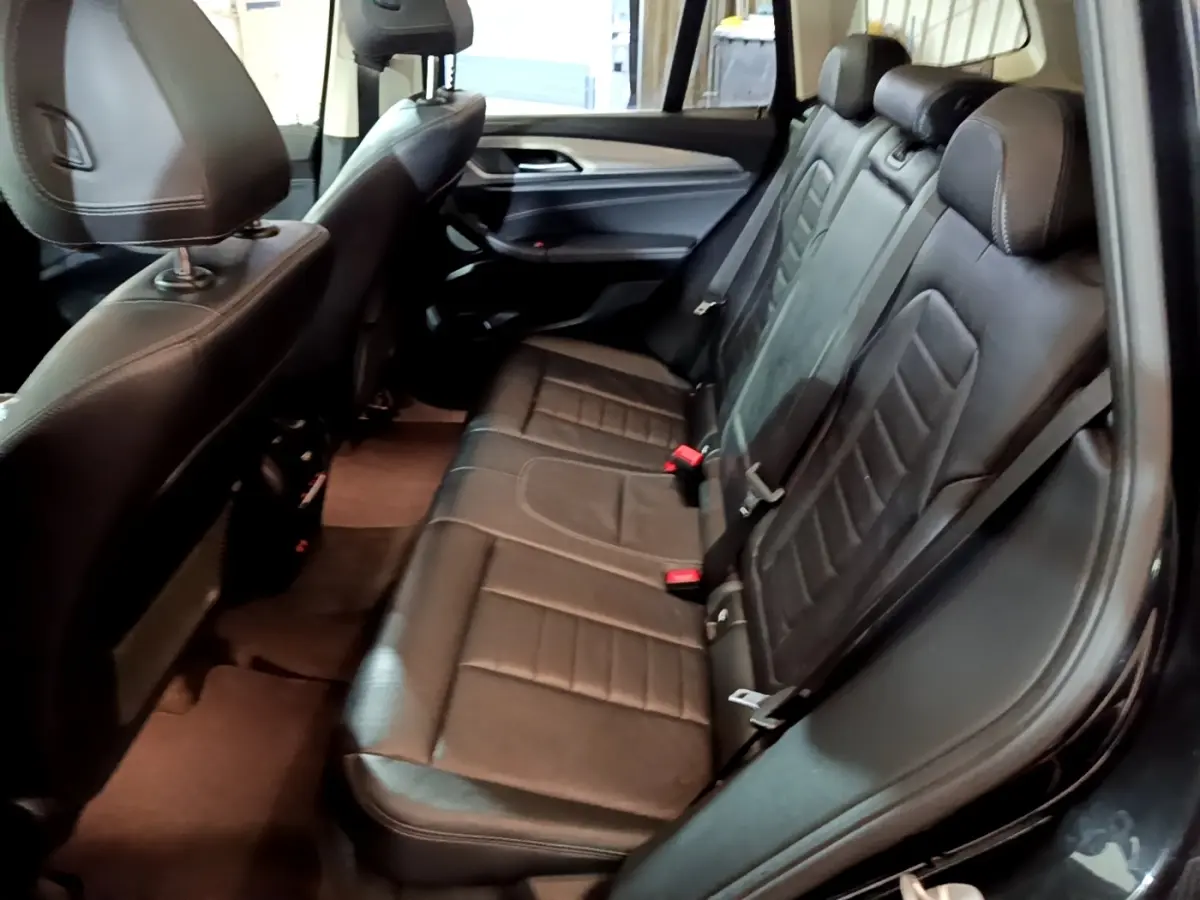 Vue intérieure côté droit montrant la banquette arrière en cuir noir du BMW X3 sDrive18d 2019.