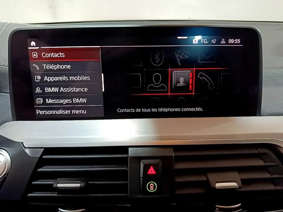 Écran tactile central du tableau de bord de la BMW X3 noir, affichant le menu contacts en intérieur.