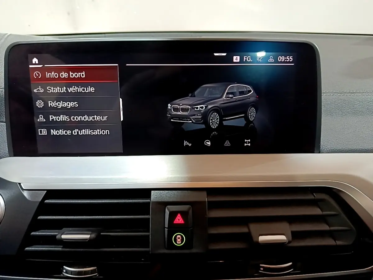 Vue intérieure de l'écran tactile affichant une BMW X3 noire en 3/4 avant sur le tableau de bord.