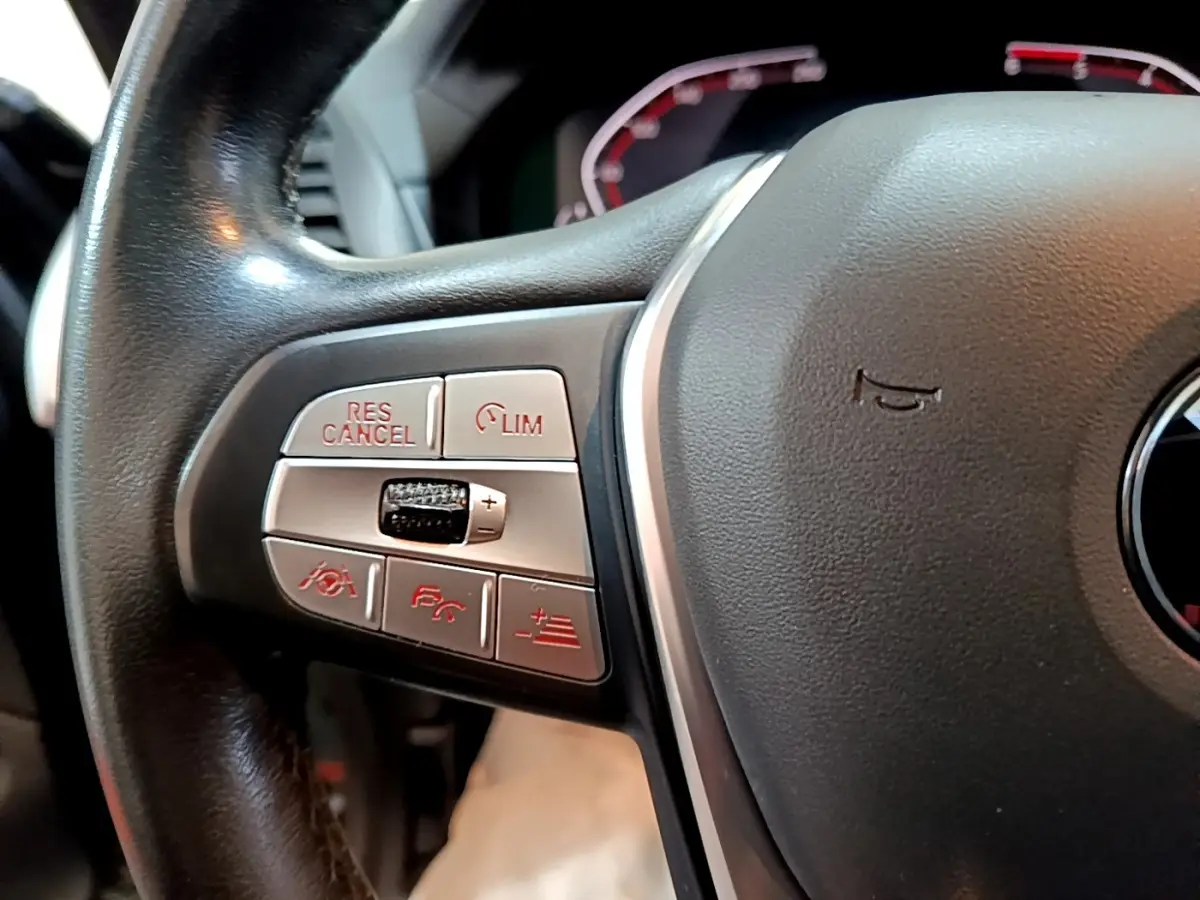 Gros plan sur le volant noir de BMW X3 2019, montrant les boutons de commande multifonctions à gauche.