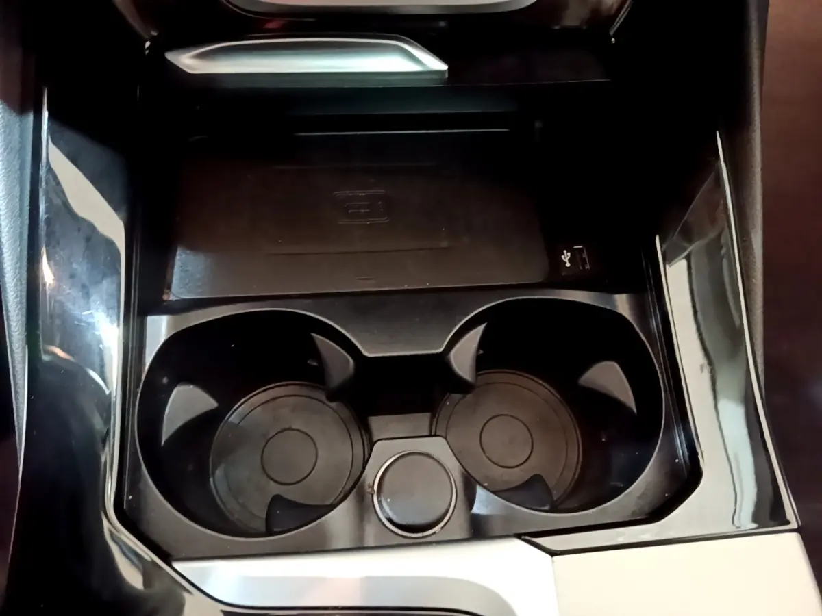 Gros plan sur le porte-gobelets noir brillant et la console centrale d’un BMW X3 sDrive18d noir de 2019.