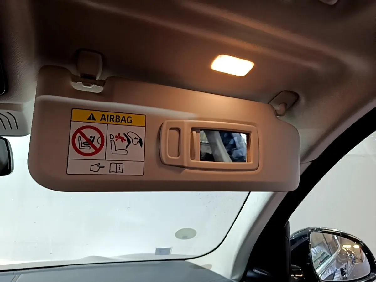 Détail du pare-soleil côté conducteur avec miroir éclairé dans un BMW X3 noir, vue intérieure avant.