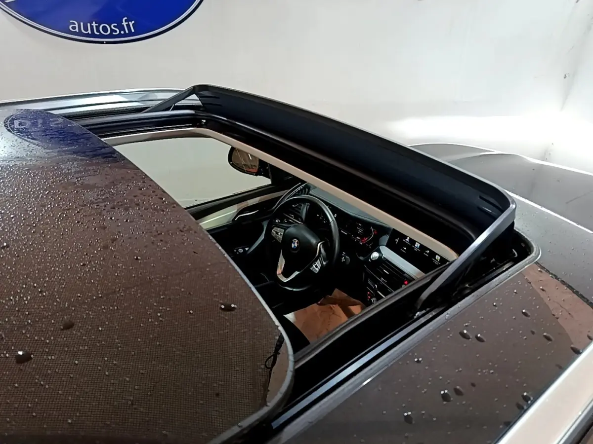 Vue plongeante sur l'intérieur noir d'un BMW X3 sDrive18d 2019 avec toit ouvrant panoramique ouvert.