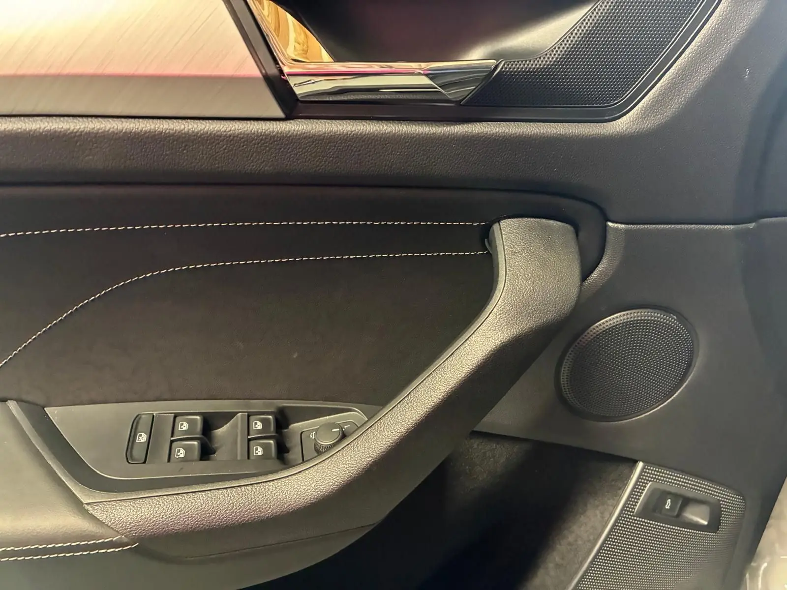 Détail de la porte côté conducteur du Skoda Kodiaq gris clair 2023, avec commandes des vitres et haut-parleur intégré.