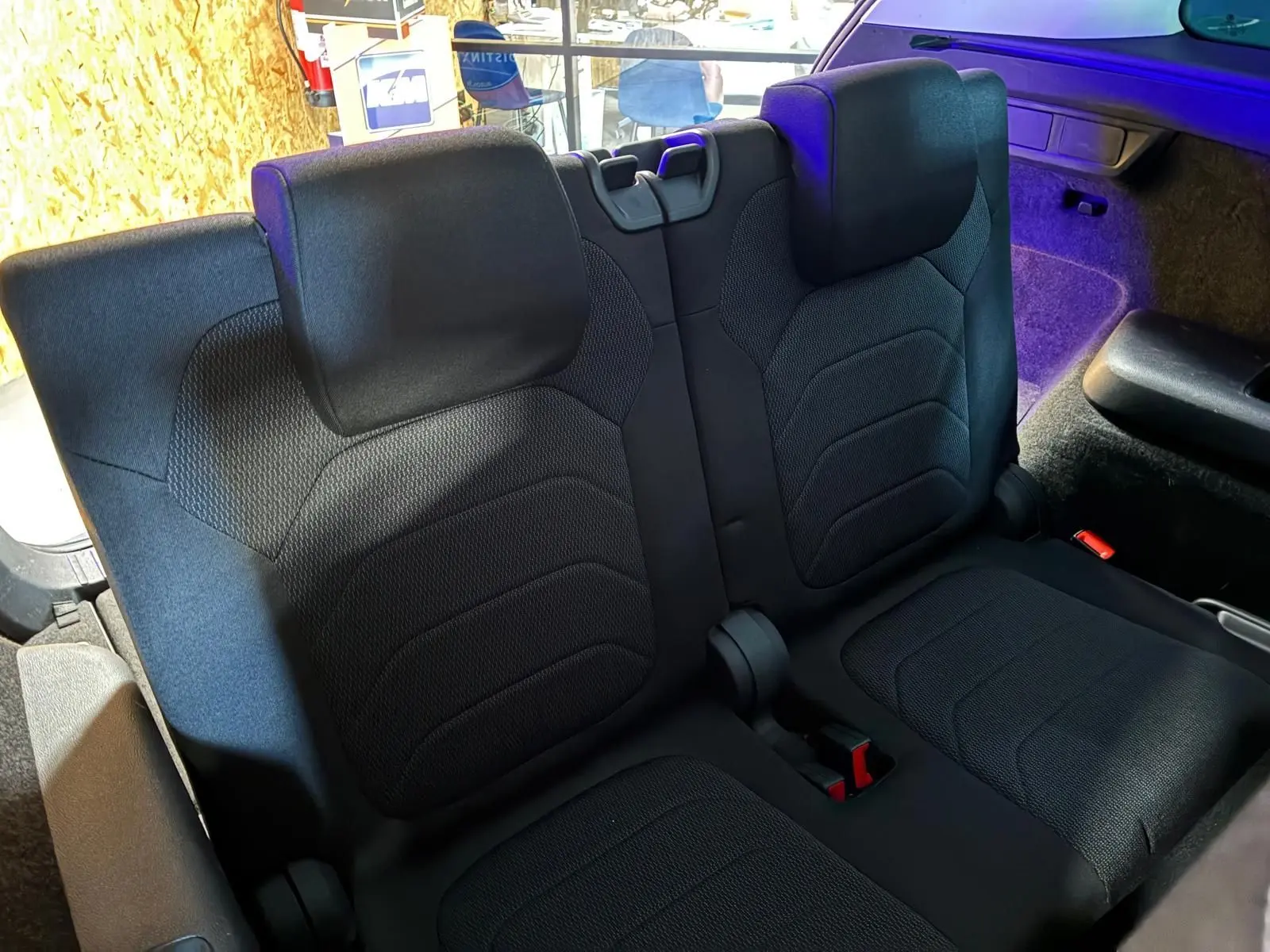 Vue rapprochée des sièges arrière en tissu noir du Skoda Kodiaq 2023, avec habillage intérieur et coffre partiellement visible.