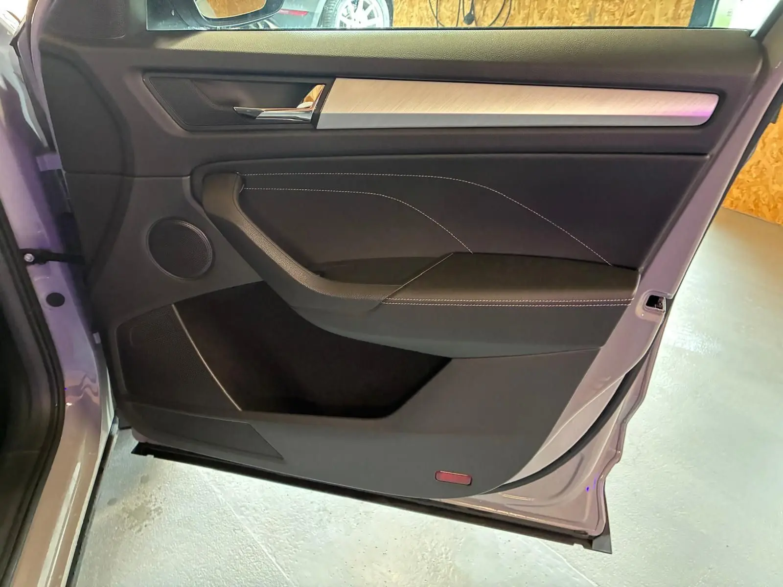 Vue rapprochée de la porte arrière gauche gris clair du Skoda Kodiaq 2023, avec garniture noire et insert décoratif clair.