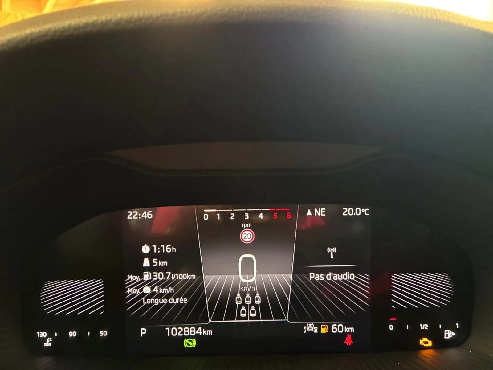 Vue rapprochée du tableau de bord numérique du Skoda Kodiaq gris clair, affichant la vitesse à 0 km/h et diverses informations de conduite.