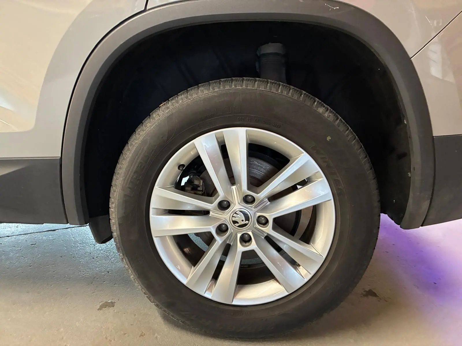 Gros plan sur la roue avant droite d'un Skoda Kodiaq gris clair 2023 avec jante alliage à 5 doubles branches.