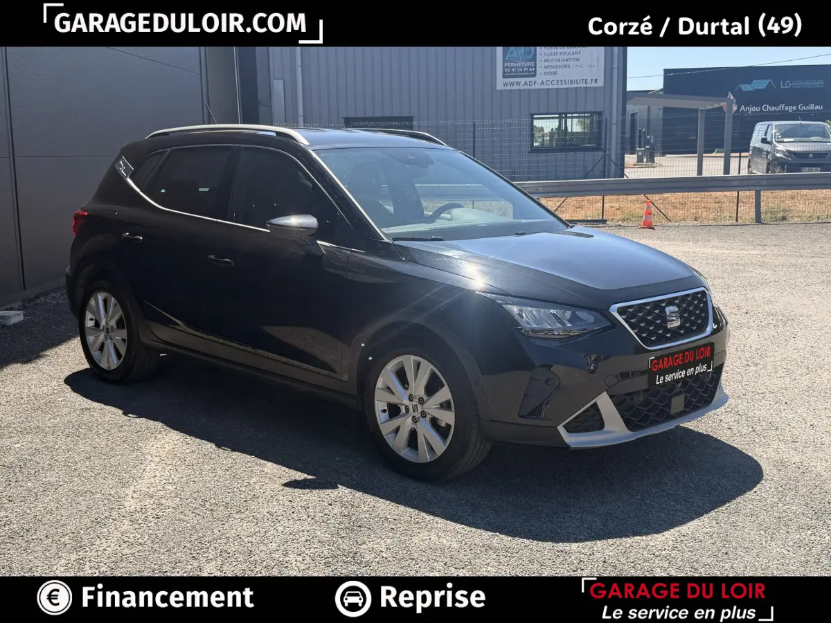 Vue 3/4 avant droit d'un SEAT Arona noir 2025 avec jantes alliage et barres de toit chromées.