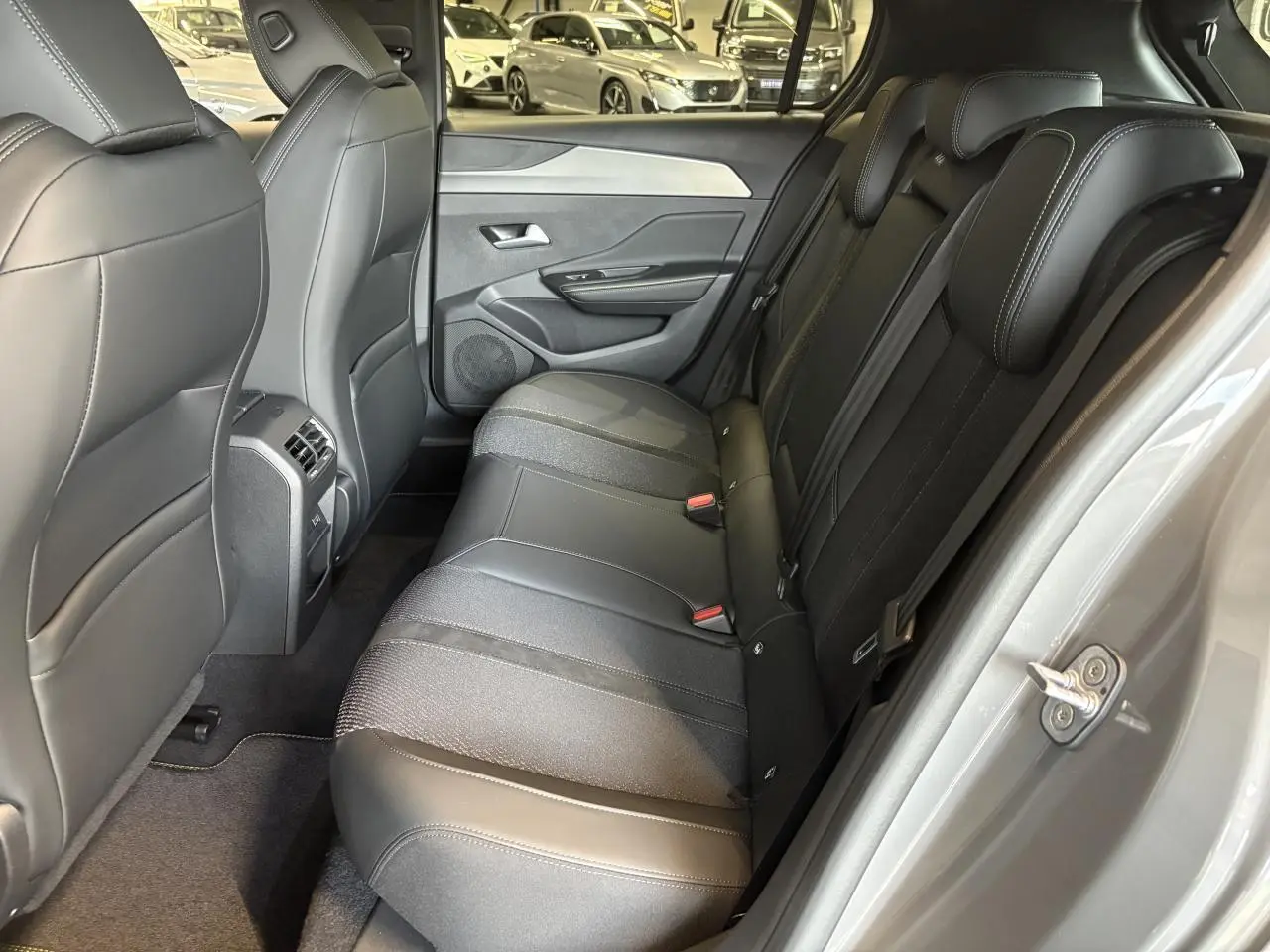 Vue intérieure côté droit sur la banquette arrière en cuir et tissu noir de la Peugeot 308 Gris Sélénium 2025.