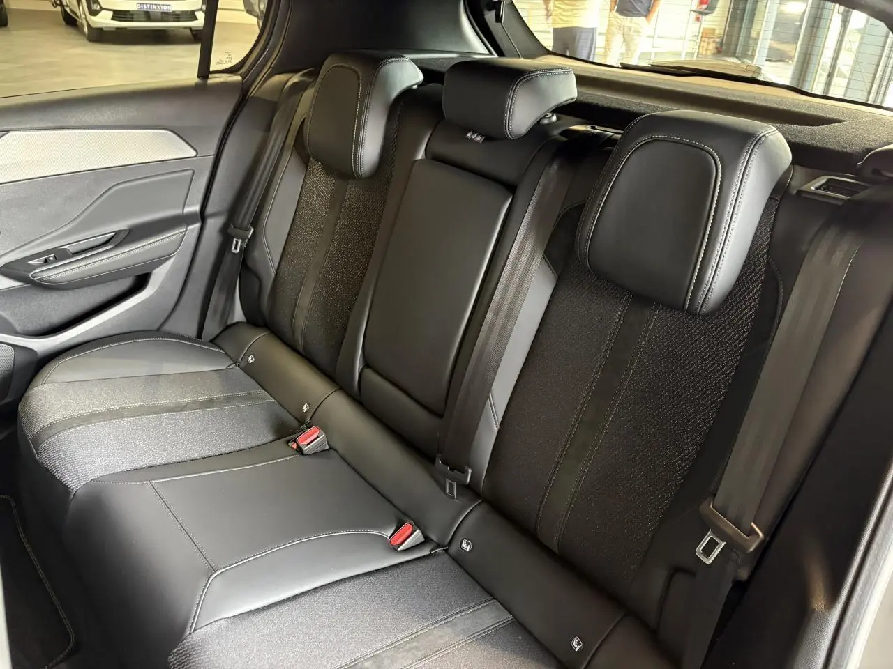 Vue intérieure de la banquette arrière en sellerie tri matières noire de la Peugeot 308 Gris Selenium 2025.