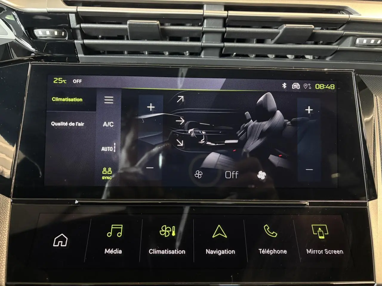 Écran tactile central de la Peugeot 308 GT 2025 affichant le menu climatisation avec interface noire et touches vertes.