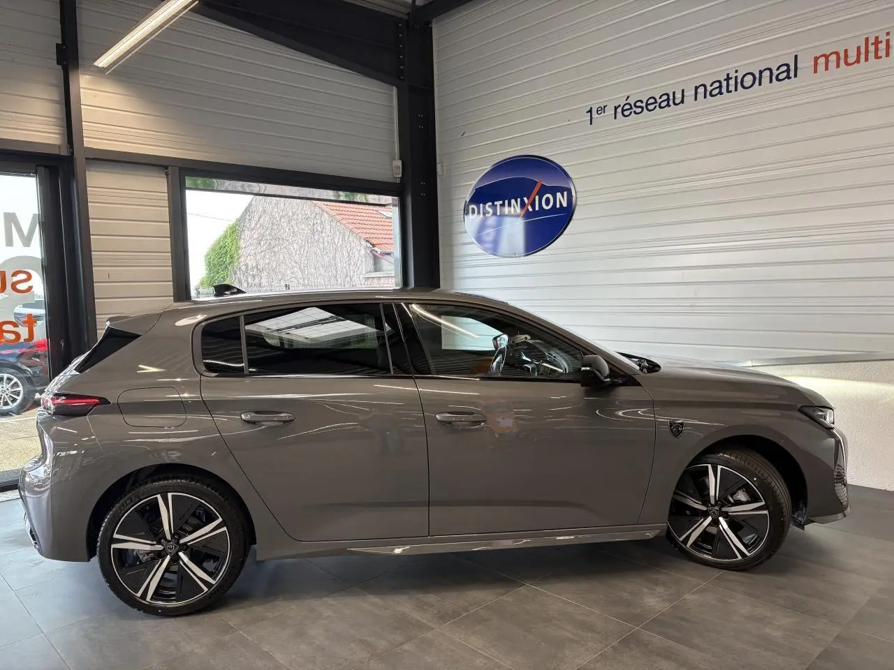 Peugeot 308 gris selenium vue de profil côté gauche, avec jantes alliage 18'' et vitres surteintées.