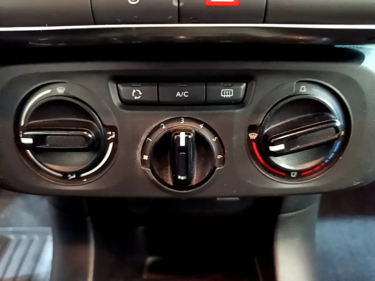 Commandes de climatisation manuelle de la Citroën C3 PureTech 68 BVM Feel 2018 en vue rapprochée, boutons noirs sur tableau de bord.