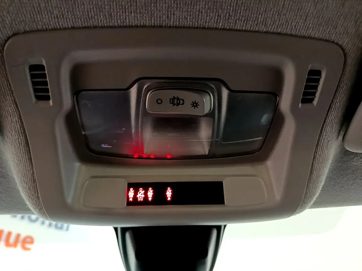 Panneau de contrôle d'éclairage intérieur avec voyants de ceinture allumés dans une Citroën C3 blanche vue de l'habitacle.