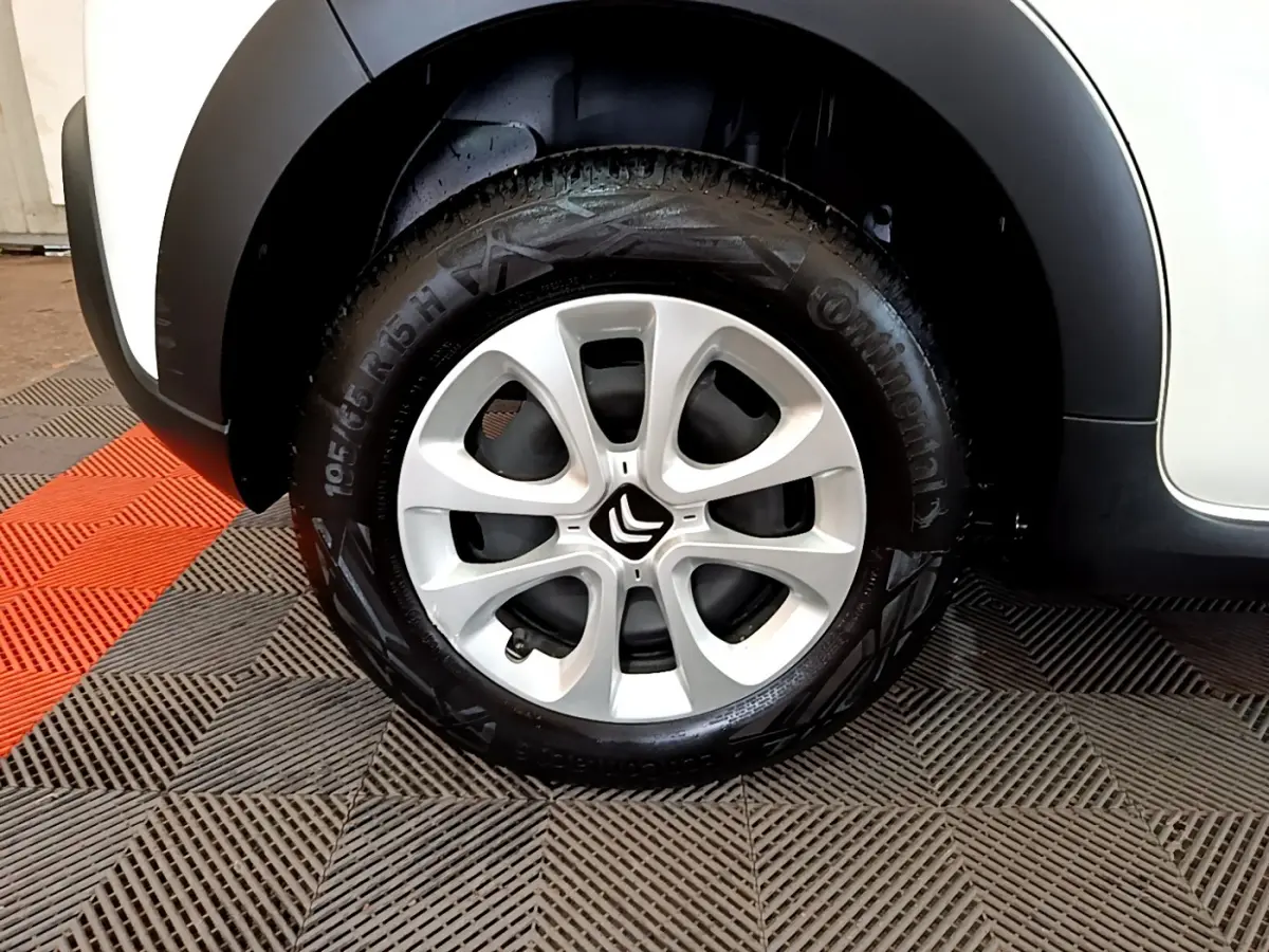 Gros plan sur la roue avant gauche de la Citroën C3 blanche, mettant en valeur la jante aluminium et le logo Citroën central.