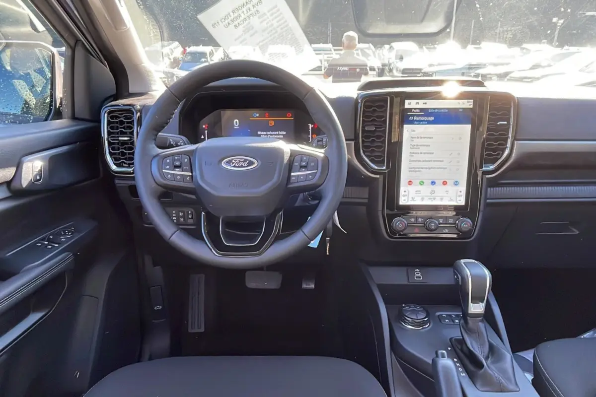 Vue intérieure du tableau de bord du Ford Ranger 2025 gris iconic, avec volant multifonction et écran tactile central vertical.