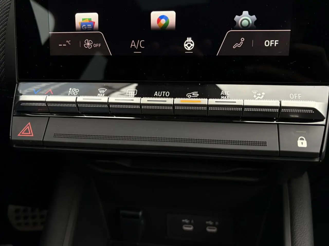 Vue rapprochée de la console centrale noire du Renault Captur 2025 avec commandes climatisation et écran tactile.