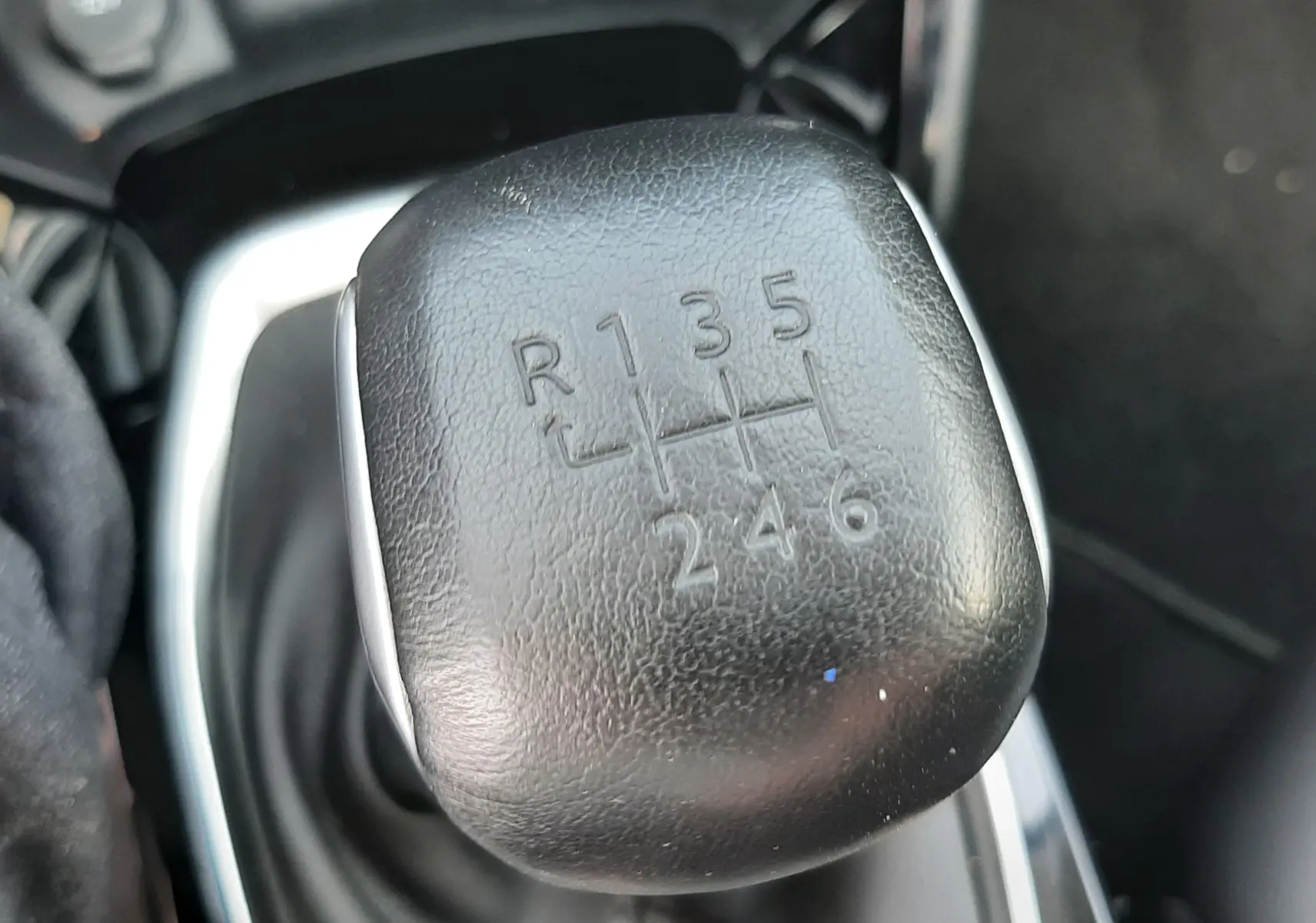 Le levier de vitesses manuel noir en gros plan dans l'habitacle d'un Peugeot 2008 gris Artense de 2022.