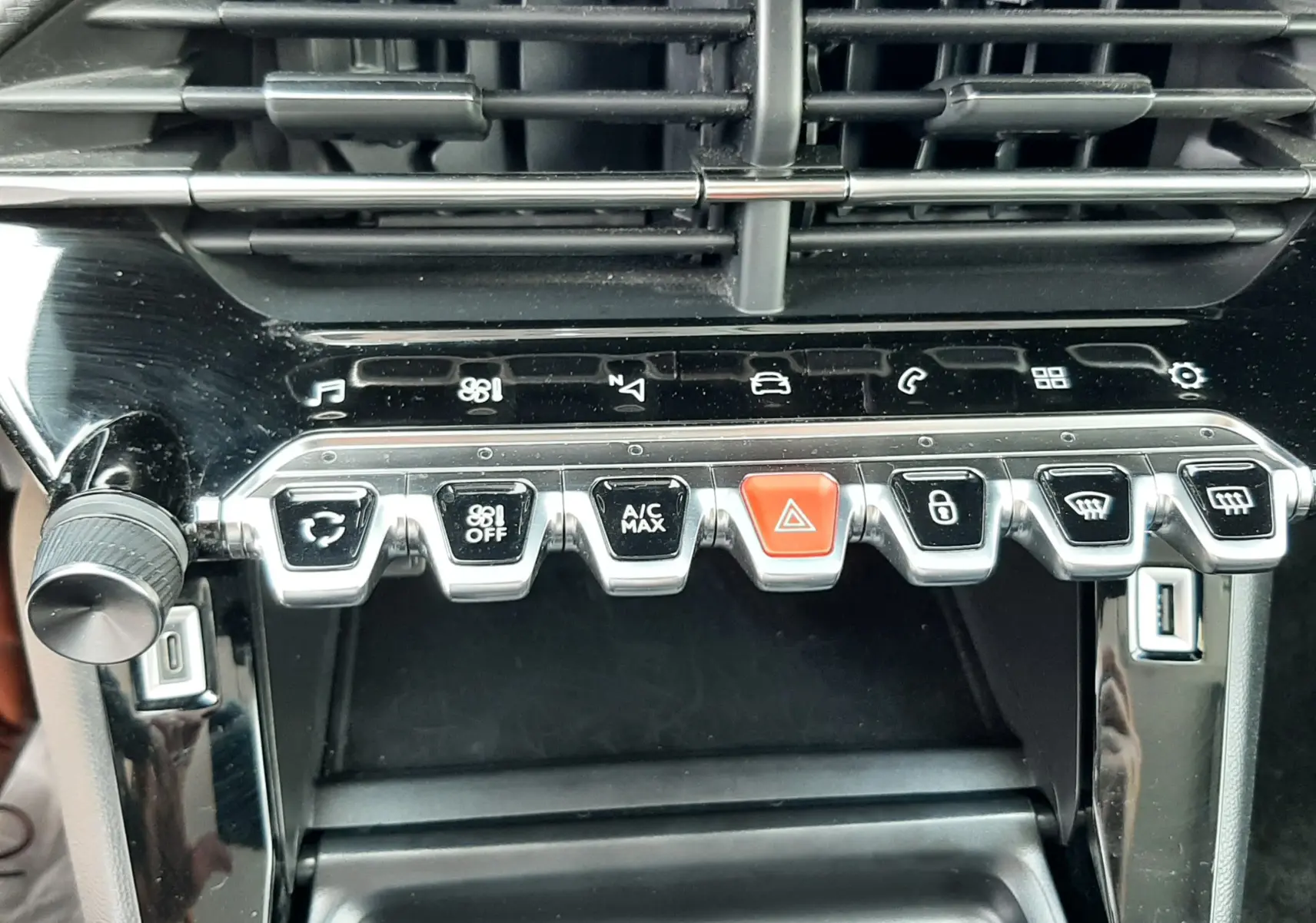 Vue rapprochée de la console centrale noire du Peugeot 2008 2022, montrant les boutons de commande et les aérateurs.