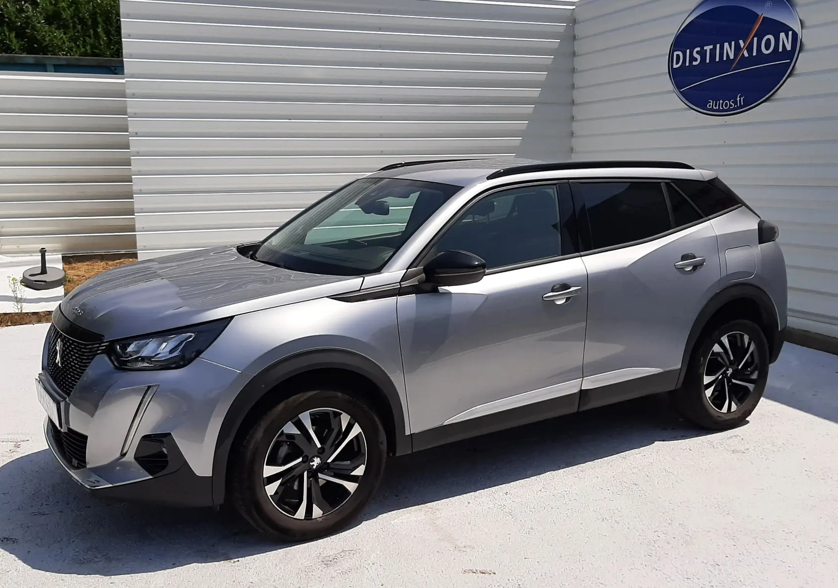 Peugeot 2008 gris Artense vue 3/4 avant droit, avec jantes alliage noires et toit noir contrasté.