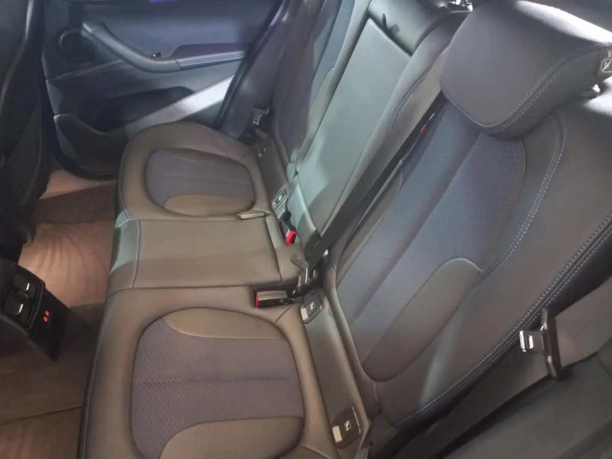 Vue intérieure des sièges arrière en cuir noir et tissu bleu foncé du BMW X1 xDrive20d M Sport 2022, côté droit.