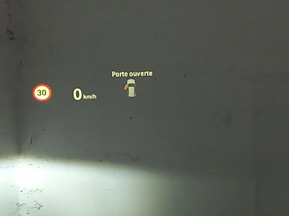 Affichage tête haute BMW X1 noir 2022 montrant vitesse à 0 km/h et alerte porte ouverte côté gauche.