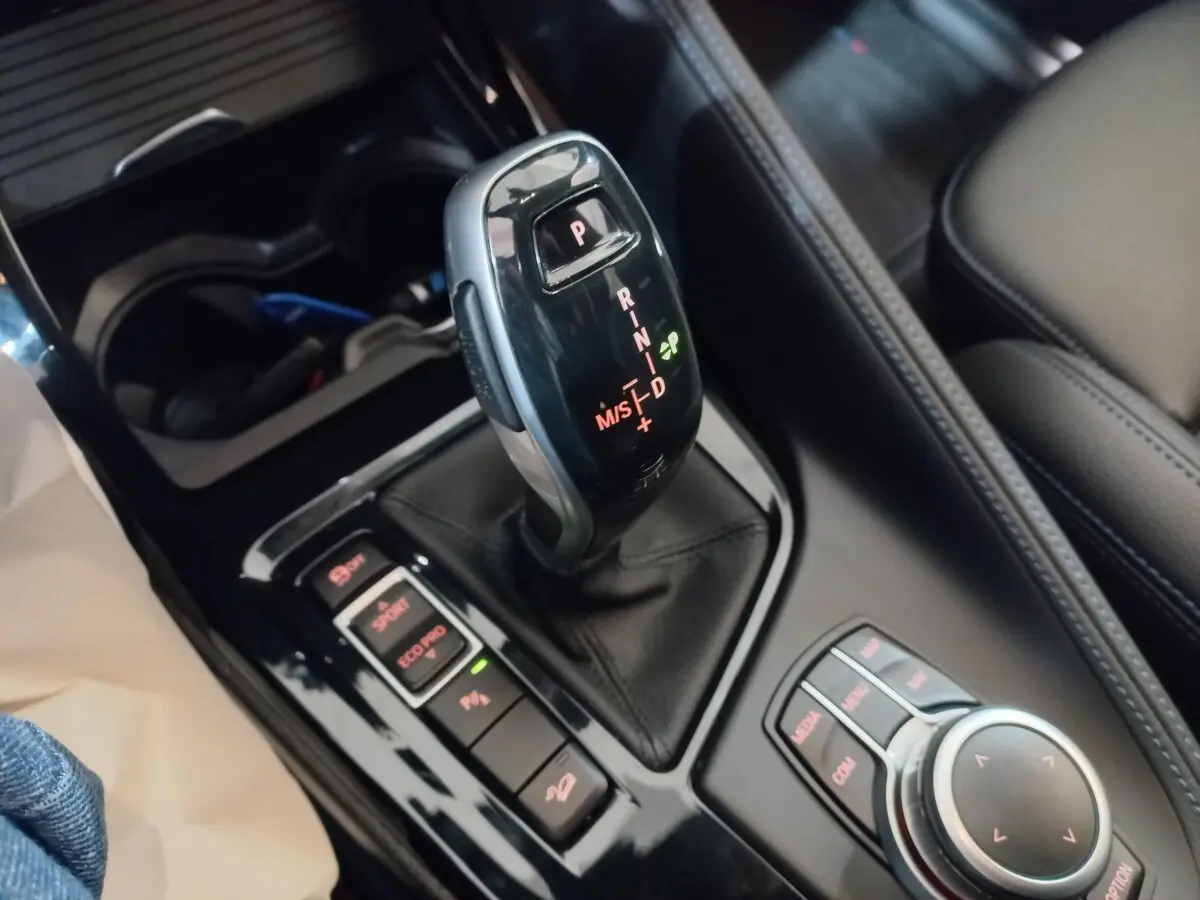 Gros plan sur la commande de boîte automatique noire et la molette de contrôle du BMW X1 xDrive20d M Sport 2022.