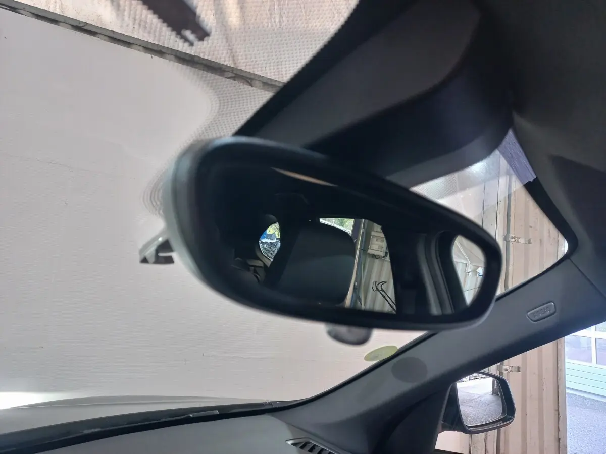 Rétroviseur intérieur d'un BMW X1 noir 2022, vue rapprochée sur l'intérieur et la vitre latérale droite.