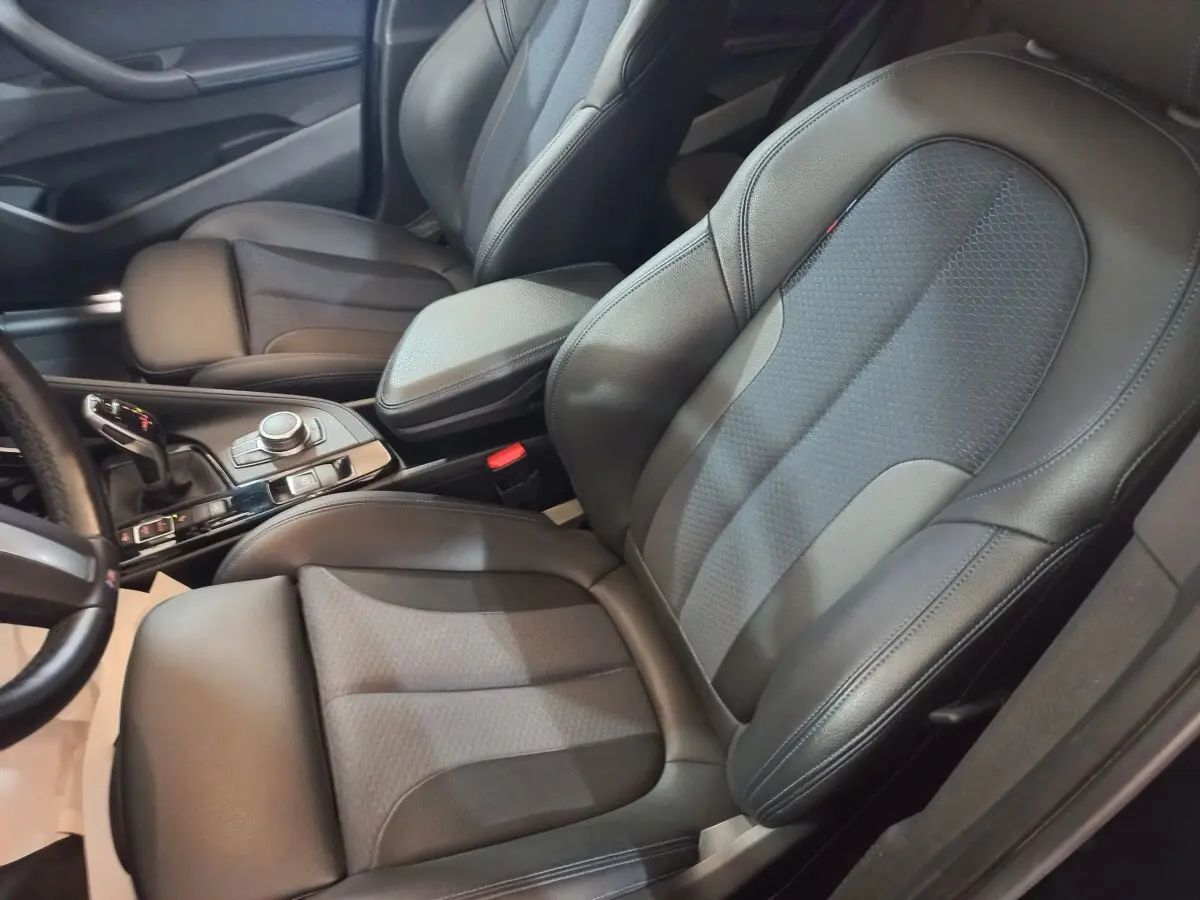Vue rapprochée des sièges avant en cuir noir et console centrale du BMW X1 xDrive20d M Sport 2022.