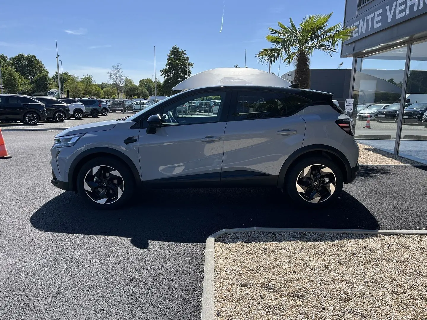 Renault Captur 2025 gris Rafale toit noir en profil droit, avec jantes noires et détails modernes visibles.
