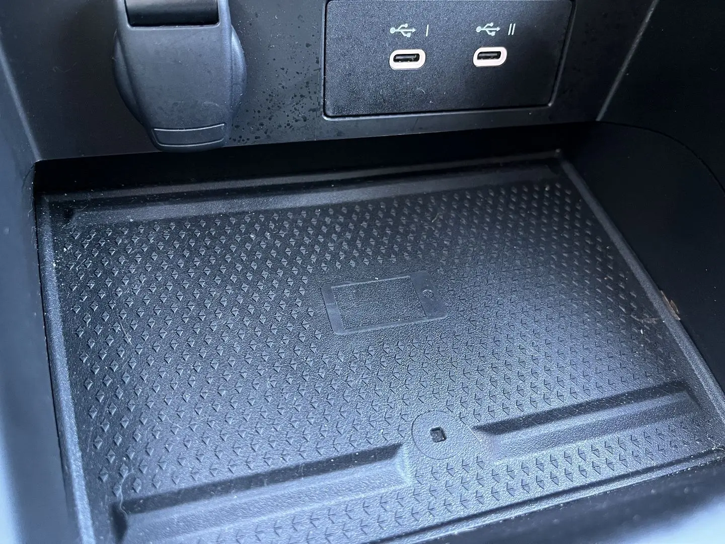 Vue écran caméra de recul montrant une Renault Captur gris Rafale avec toit noir, garée près d’un bâtiment industriel.