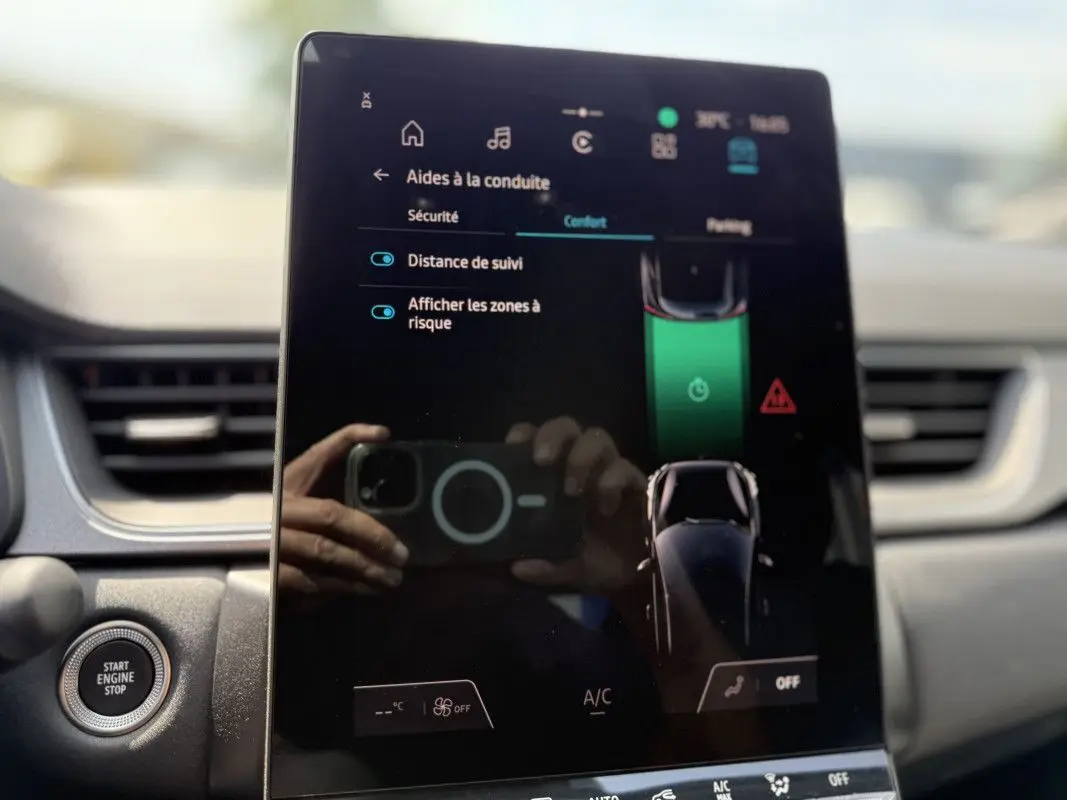 Écran tactile central du Renault Captur 2025 affichant les aides à la conduite, avec bouton start/stop visible à gauche.
