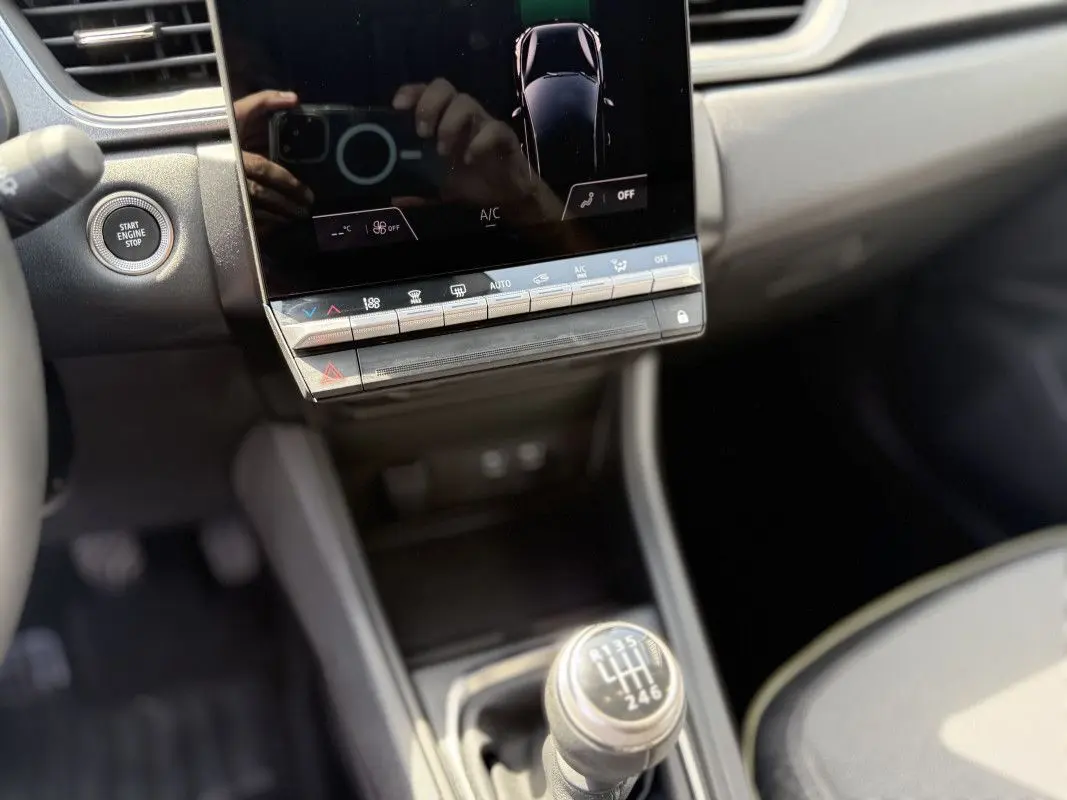Gros plan sur la console centrale du Renault Captur 2025, montrant la boîte manuelle et l'écran tactile.