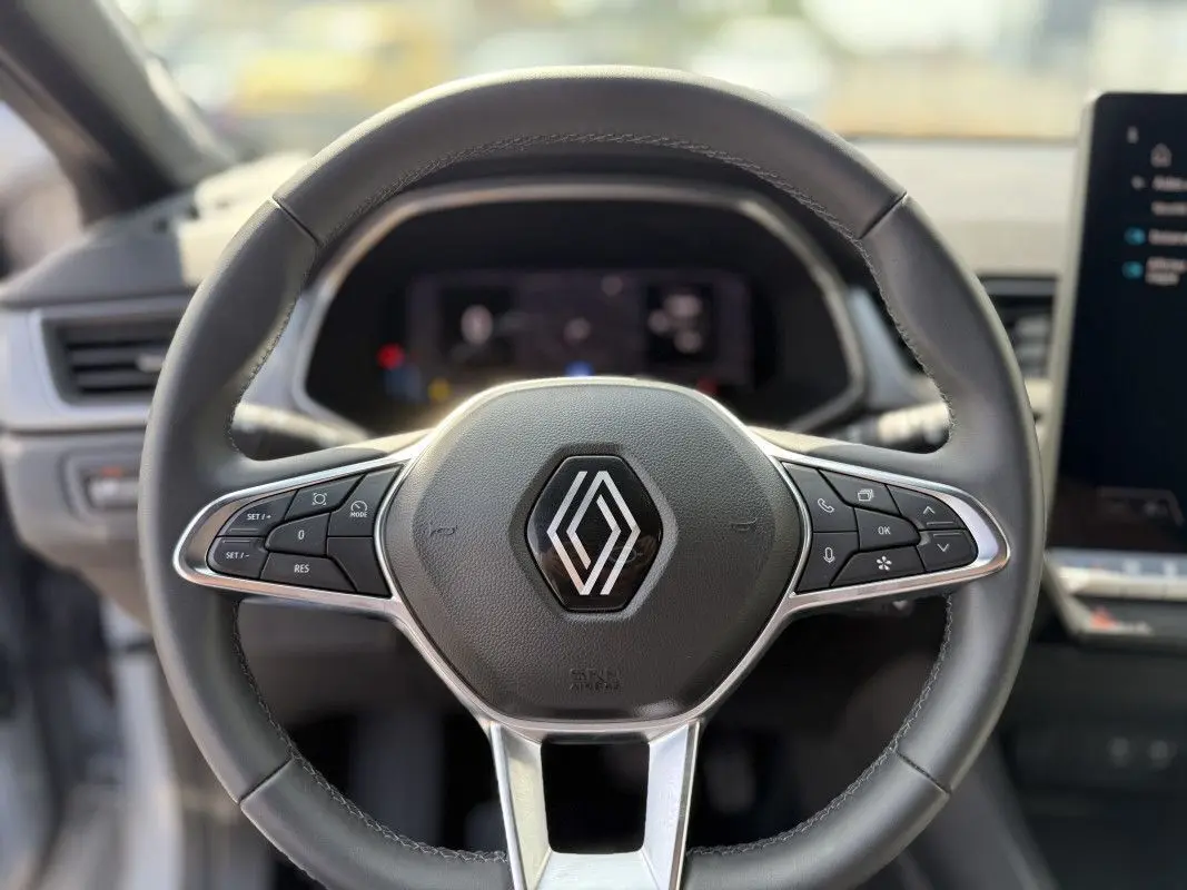 Volant cuir noir de Renault Captur 2025 vu de face, avec commandes intégrées et logo chromé central.