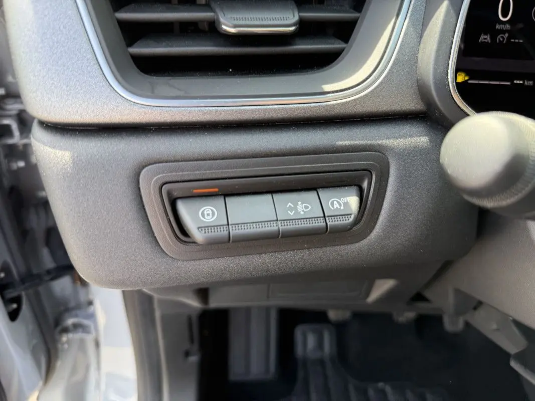 Gros plan sur les commandes sous la ventilation côté conducteur du Renault Captur gris Rafale 2025 avec toit noir.