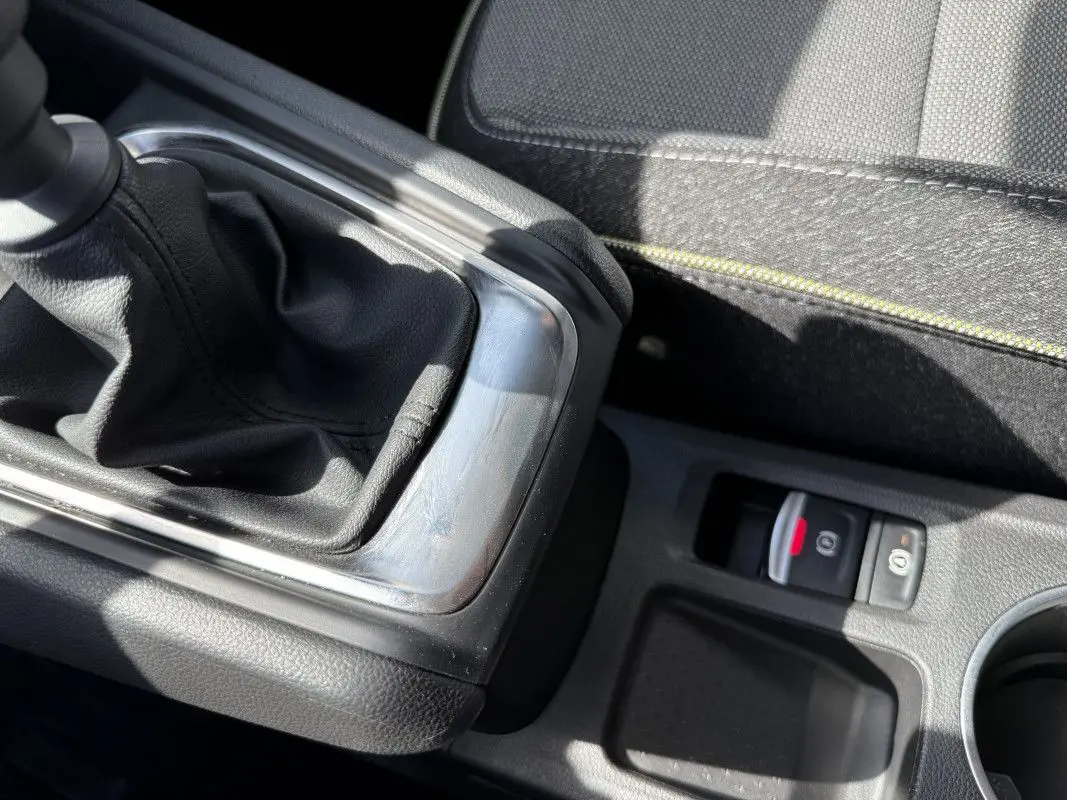 Gros plan sur le levier de vitesses manuel et le frein à main électronique du Renault Captur gris Rafale, intérieur tissu noir.