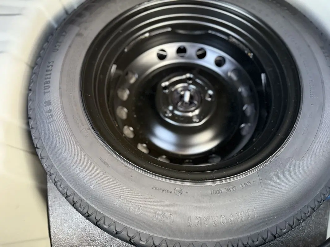Gros plan sur la roue de secours noire du coffre du Renault Captur gris Rafale toit noir 2025.