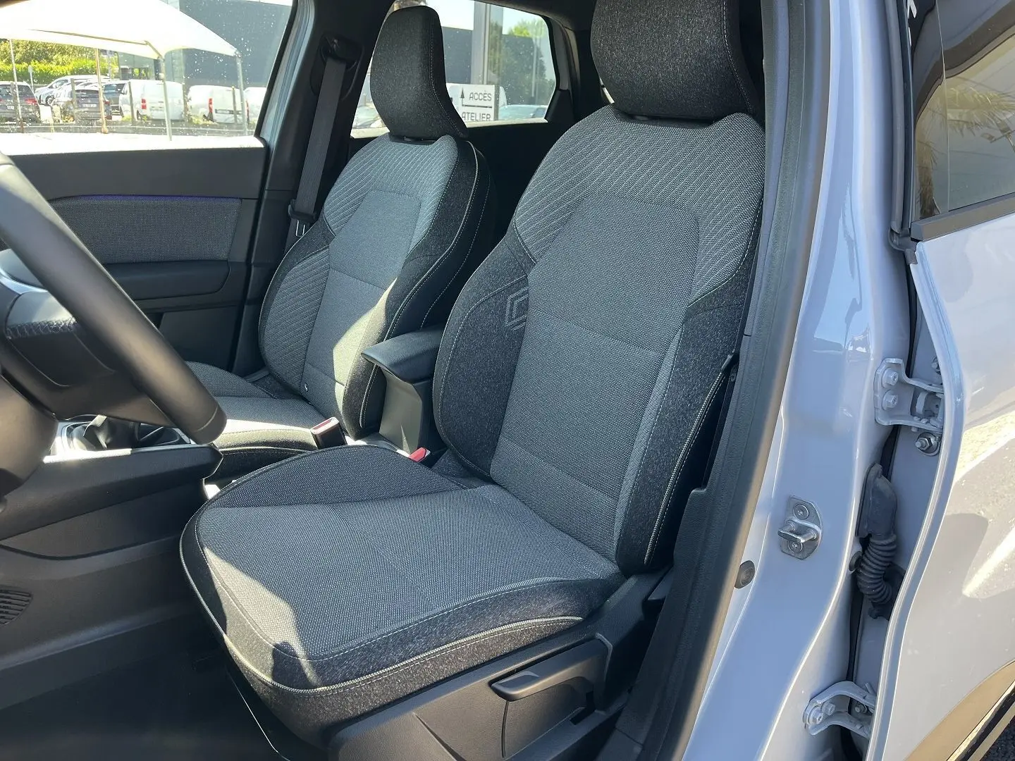 Gros plan sur la roue avant droite du Renault Captur gris Rafale avec jante noire et argentée au design étoilé.