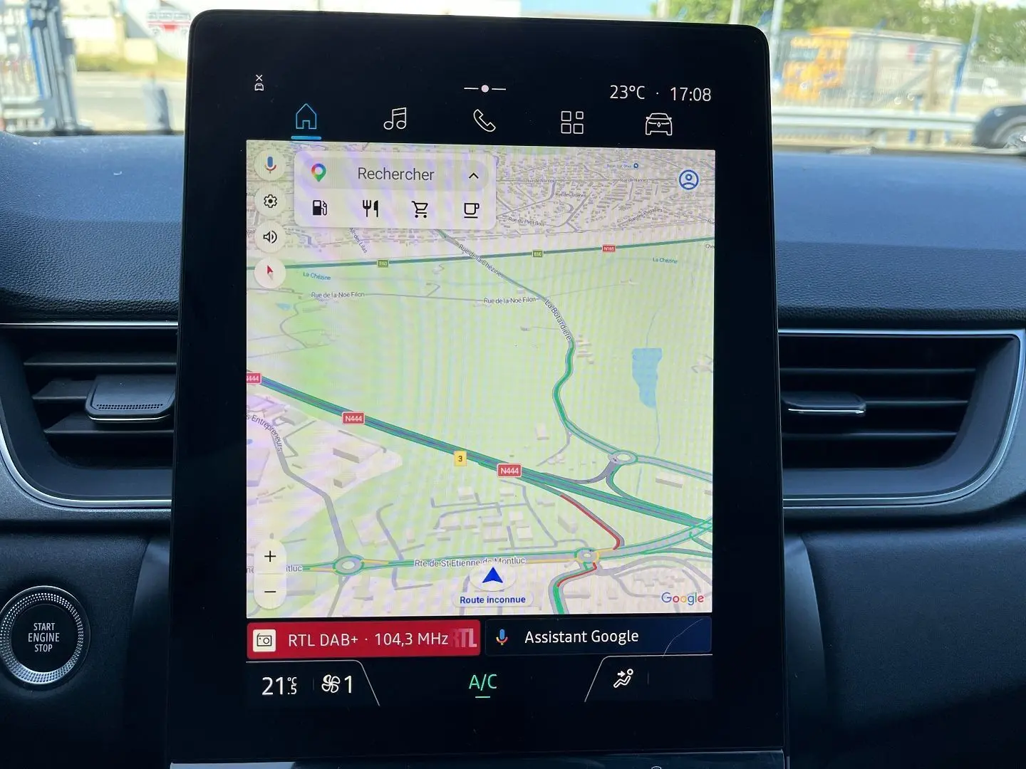 Vue intérieure du tableau de bord du Renault Captur 2025, écran tactile central affichant la navigation et commandes climatisation.