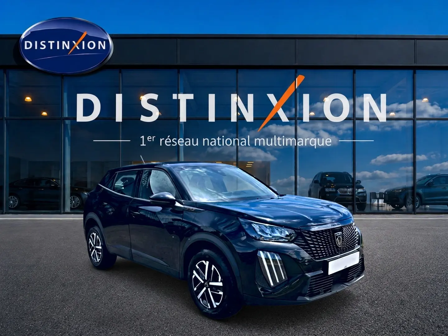 Peugeot 2008 noir en 3/4 avant droit, avec calandre distinctive et feux LED verticaux, devant showroom Distinxion.