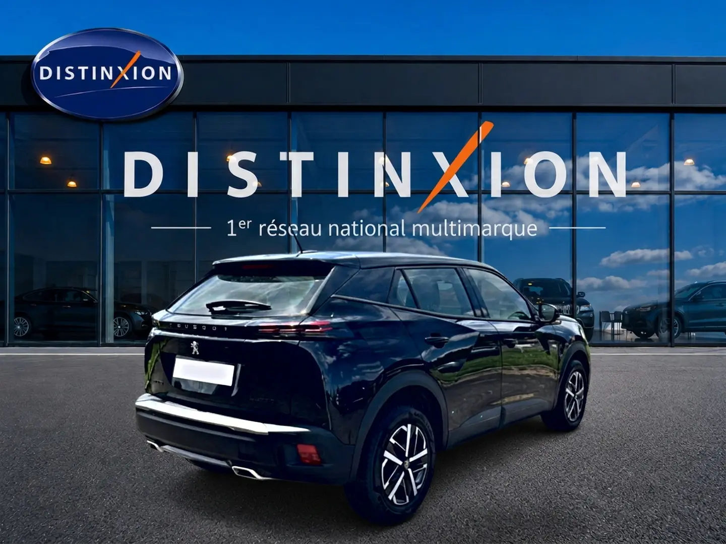 Vue 3/4 arrière droite d’un Peugeot 2008 noir brillant avec feux arrière LED et becquet, devant une vitrine Distinxion.