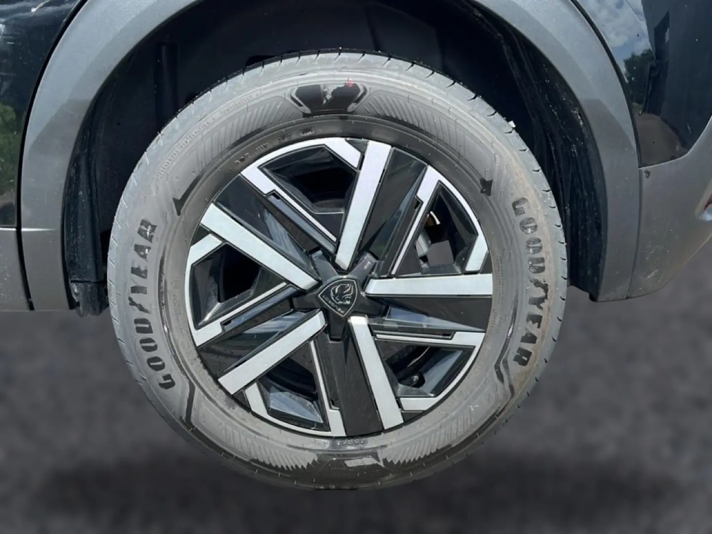 Gros plan sur la roue avant droite noire avec jante alliage bicolore du Peugeot 2008 1.2 hybrid 145 style e-dcs6 2025.