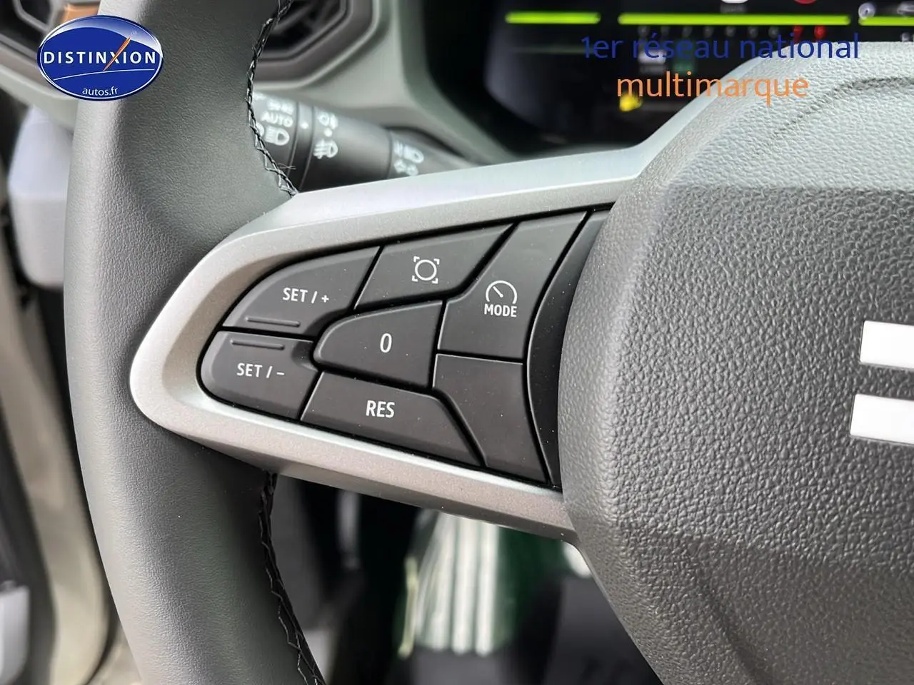 Gros plan sur les commandes multifonctions à gauche du volant du Dacia Duster 2025 couleur Sandstone.